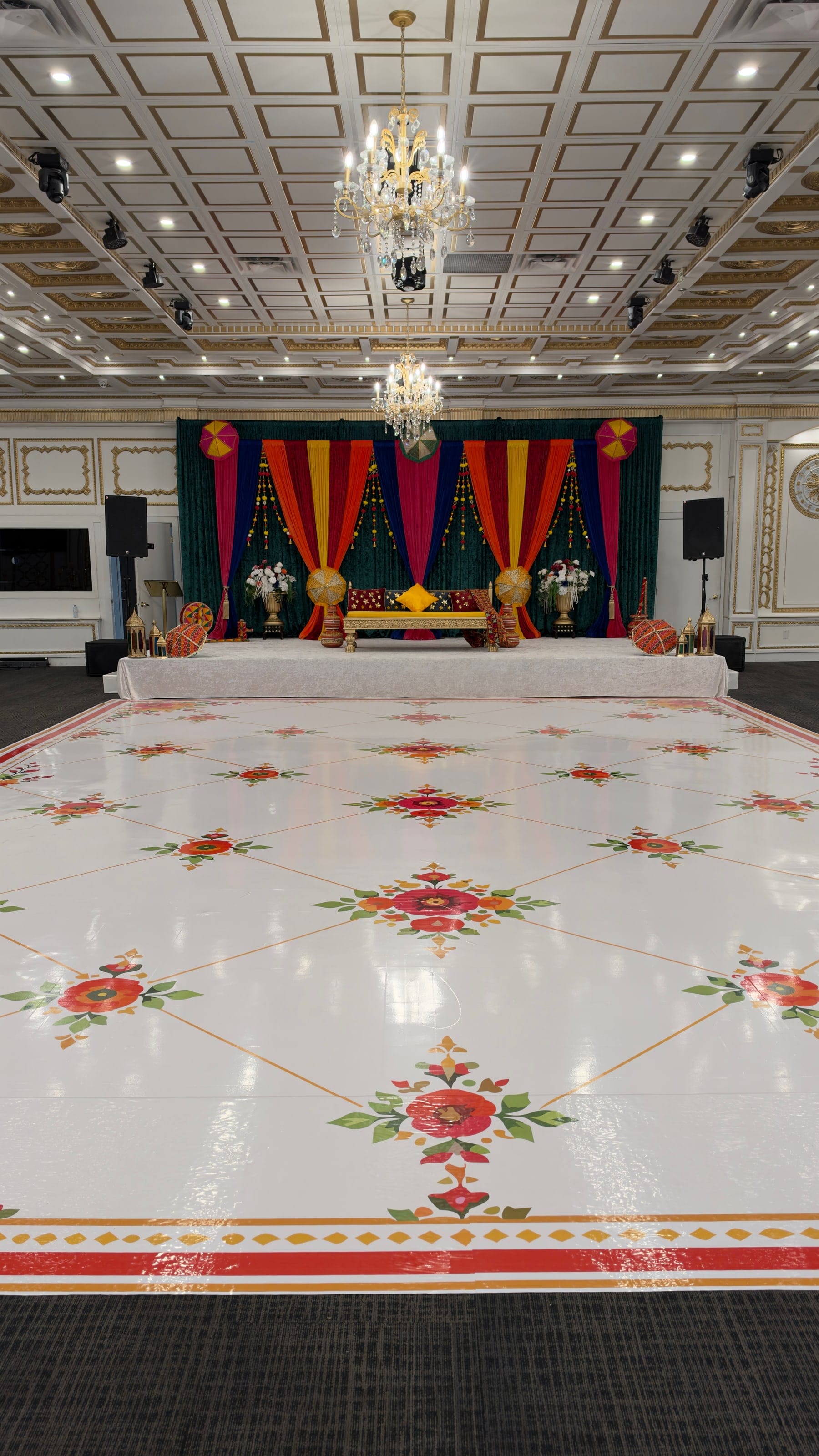 Wedding stage beneath a crystal chandelier, lit in warm gold